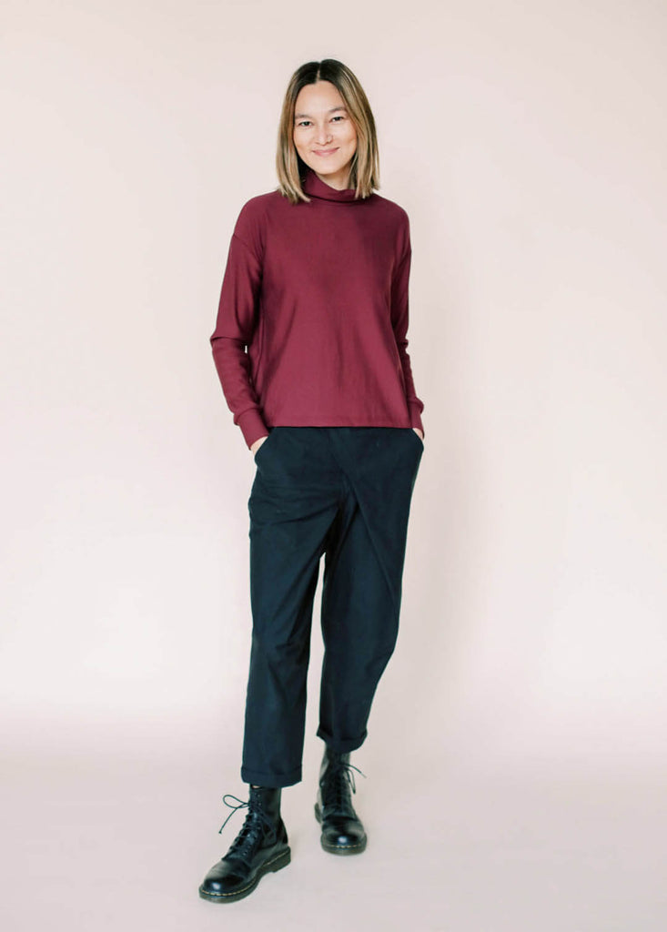 a straight size woman wearing a burgundy roll neck sweatshirt