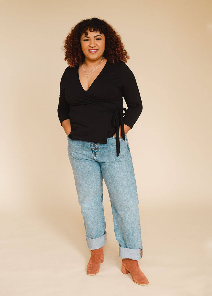 a mid sized woman wearing a black wrap top
