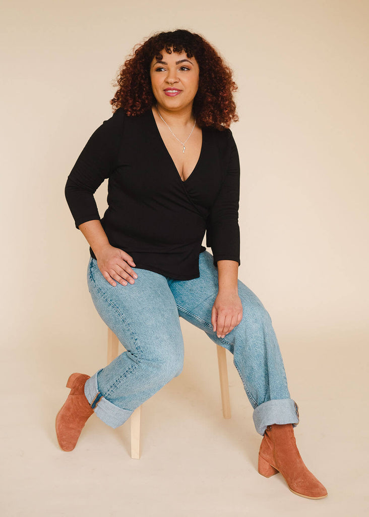 a mid sized woman wearing a black wrap top