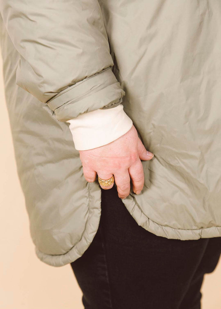 a close up of a plus size woman wearing a cream roll neck sweatshirt