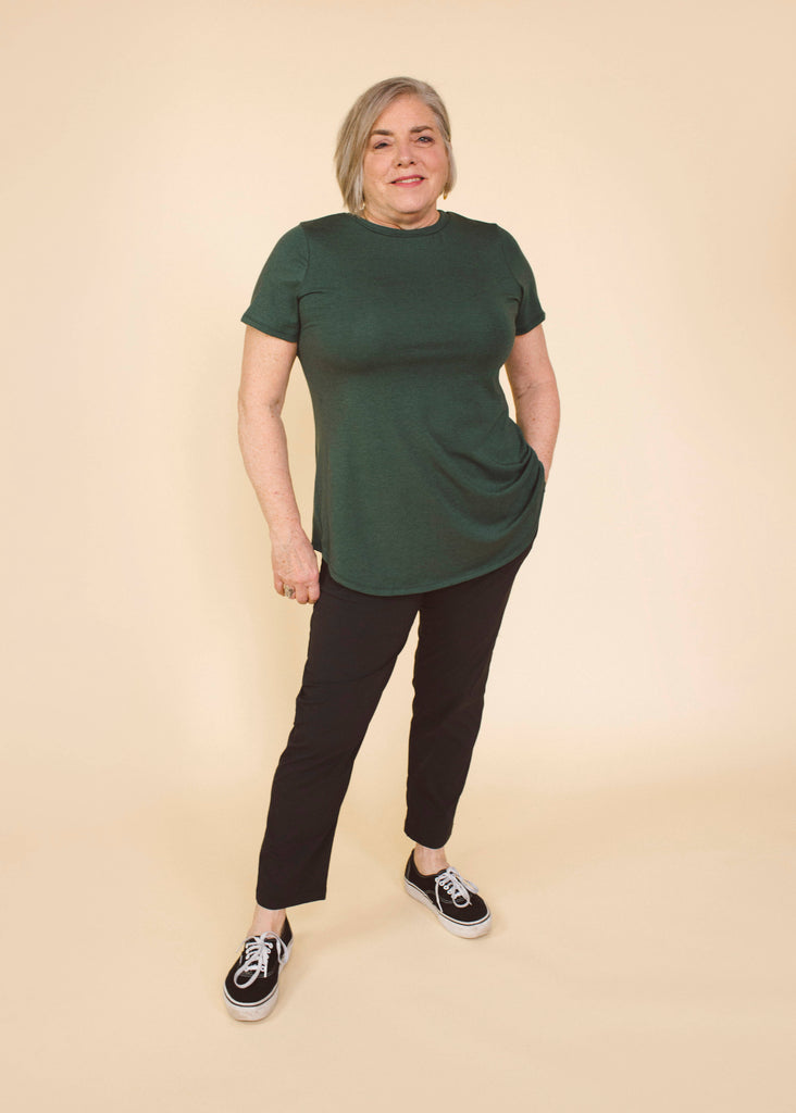 a mid size woman wearing a green long line tee