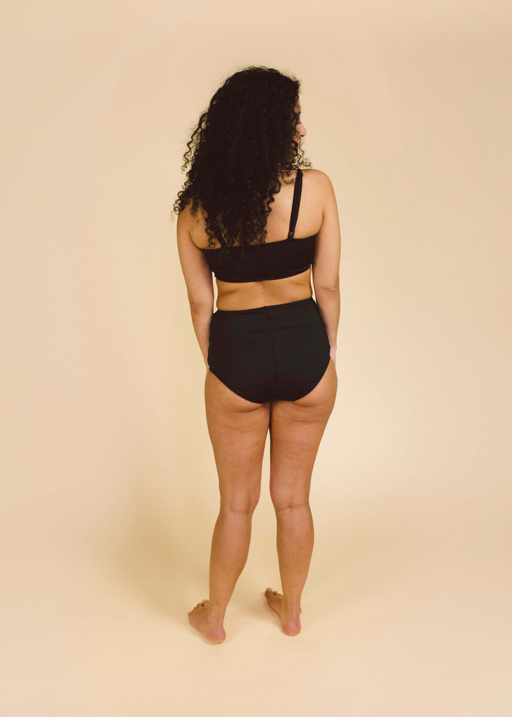 a straight size woman wearing a black bikini